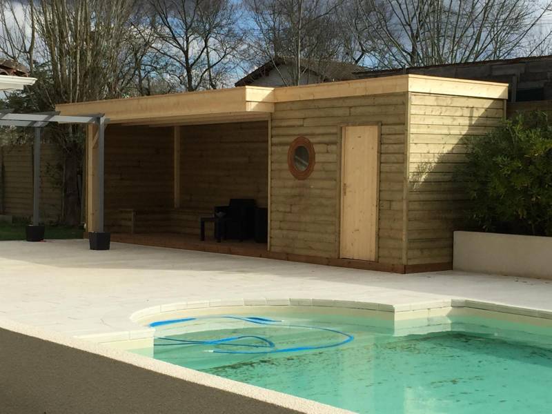 Réalisation d’un pool house avec local technique, assise intégrée et hublot en bardage bois à Martillac